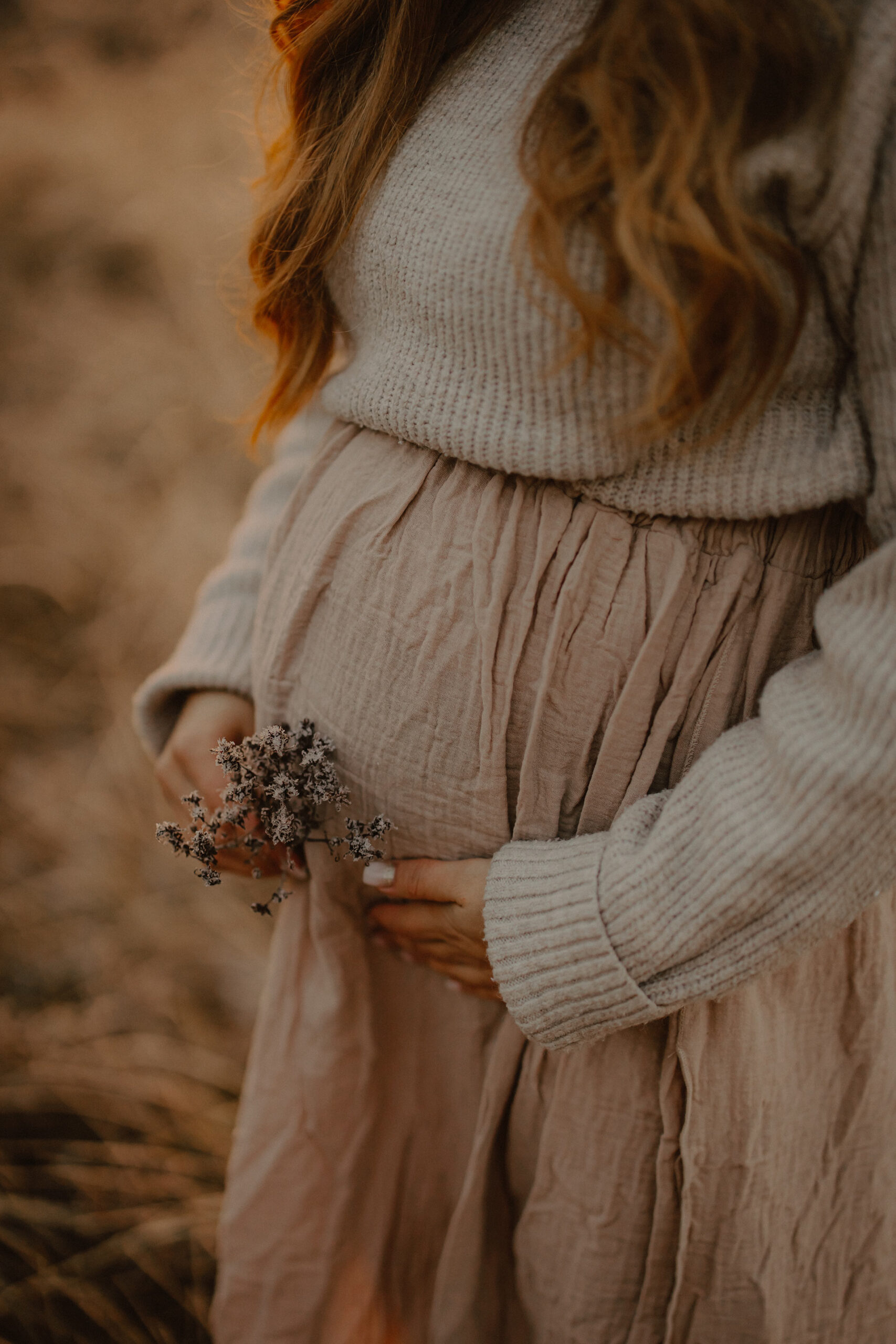 Schwangere Frau mit Blumen in der Hand