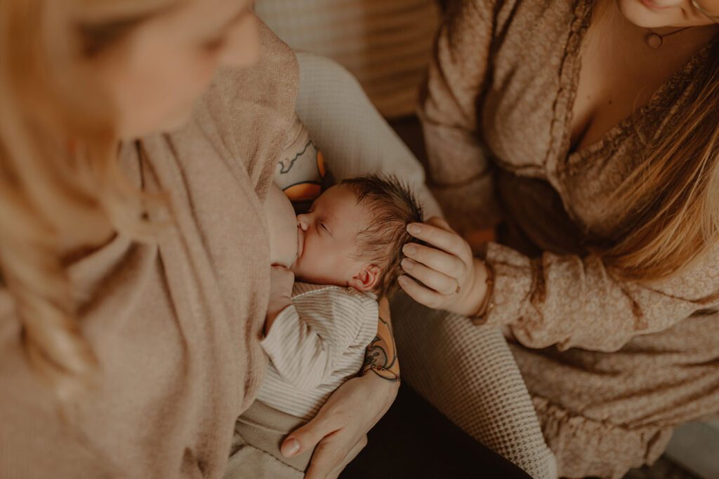 Frau still Baby und wir dabei von einer Hebamme beraten